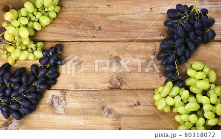 White grapes on a wooden background. Juicy and ripe bunches of grapes. Top view. Free space for 80318072