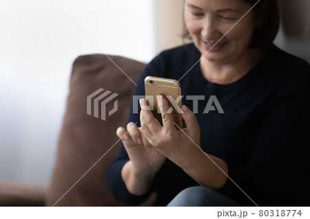 Happy older 60s woman using telehealth app on mobile phone 80318774