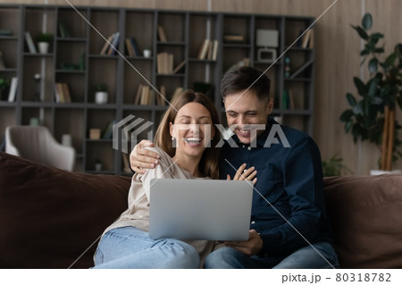 Happy Caucasian couple rest at home using laptop Happy Caucasian couple rest at home using laptop 80318782