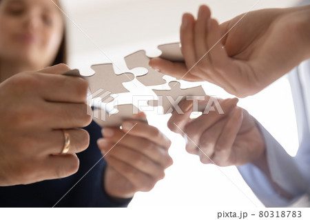 Hands of business team connecting four pieces of puzzle 80318783