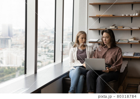 Focused two female colleagues working on computer in modern office. Focused two female colleagues working on computer in modern office. 80318784