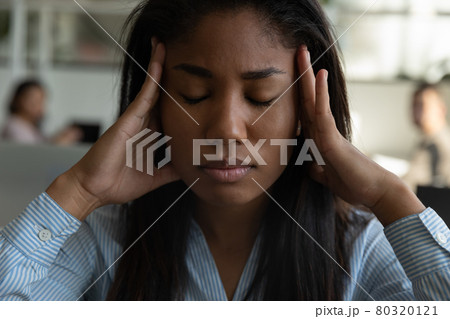 Stressed tired mixed race black office employee suffering from headache 80320121