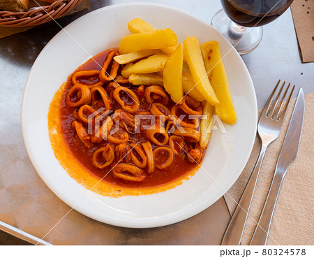 Squid rings stewed in sauce americaine served with fries 80324578