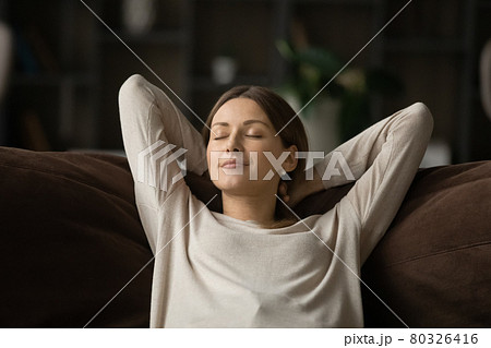 Mindful happy relaxed young woman sleeping on comfortable sofa. 80326416