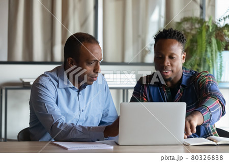 Two African American employees working on project together, using laptop Two African American employees working on project together, using laptop 80326838