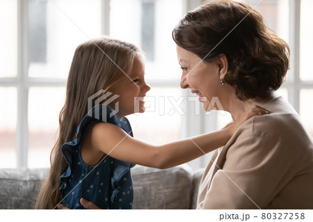 Happy small granddaughter and senior grandmother play at home Happy small granddaughter and senior grandmother play at home 80327258