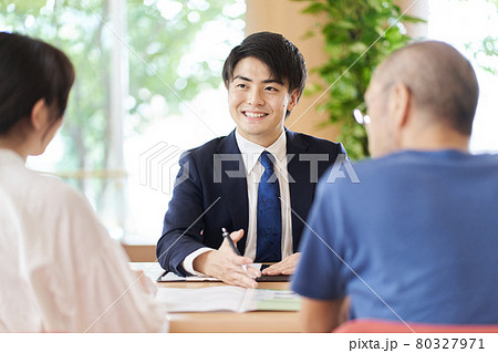 親子から相談を受ける営業職の男性 80327971