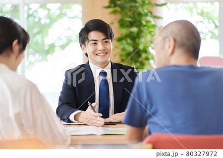親子から相談を受ける営業職の男性 80327972