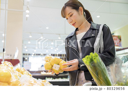 スーパーでみかんを手にする女性買い物客　買い物イメージ 80329656