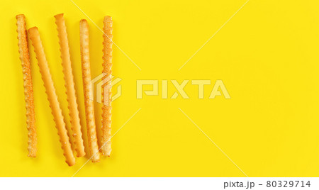Grissini, also known as breadsticks on yellow board, view from above space for text right side 80329714