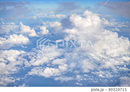 Fluffy sky clouds lit by afternoon sun, as seen from commercial airplane flying over Fluffy sky clouds lit by afternoon sun, as seen from commercial airplane flying over 80329715
