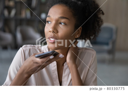 Close up smiling African American woman recording audio message Close up smiling African American woman recording audio message 80330775