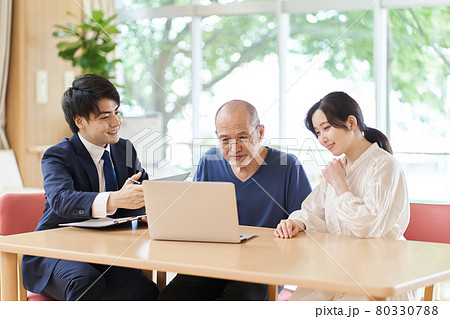 パソコン画面を見ならが説明を受ける高齢者 80330788