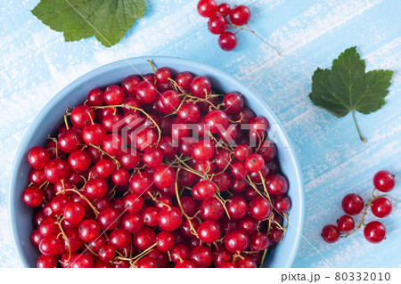 Fresh red currant in wooden bowl on dark table 80332010