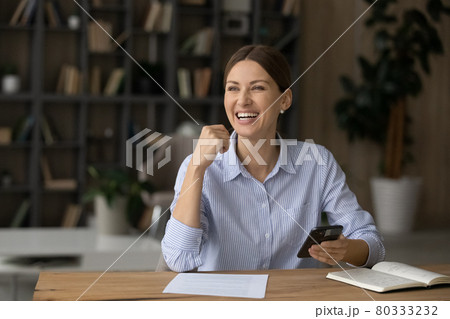 Excited young businesswoman getting message with good news. 80333232