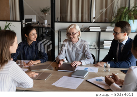 Happy mature female business leader talking to team, giving instructions 80334011