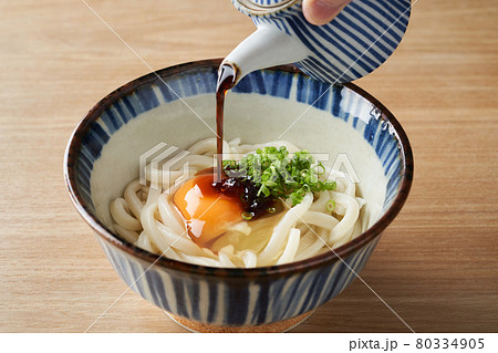 釜玉うどんに出汁醤油をかける 80334905