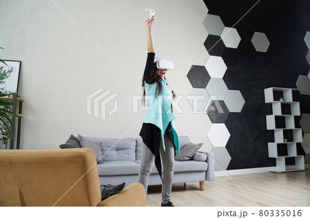 Woman with virtual reality headset is playing game. 80335016