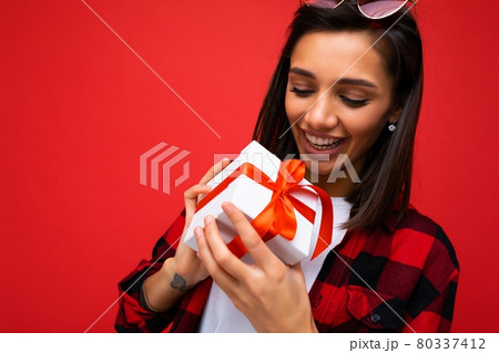Closeup portrait photo of beautiful happy young brunet female person isolated on red background wall Closeup portrait photo of beautiful happy young brunet female person isolated on red background wall 80337412