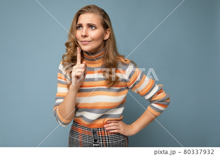 Portrait of young blonde beautiful curly woman with sincere emotions wearing striped sweater 80337932