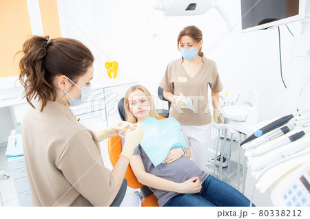 pregnant woman at the dentist's office, checkup and dental treatment for pregnant women. pregnant woman at the dentist's office, checkup and dental treatment for pregnant women. 80338212