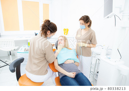 pregnant woman at the dentist's office, checkup and dental treatment for pregnant women. pregnant woman at the dentist's office, checkup and dental treatment for pregnant women. 80338213
