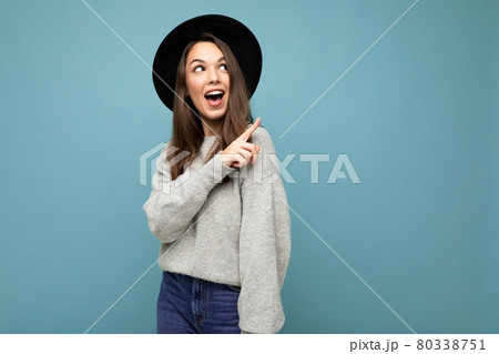 Photo of attractive brunette happy shocked joyful young woman pointing finger at free space for text 80338751