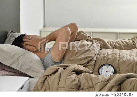 Depressed young Asian man lying in bed cannot sleep from insomnia Depressed young Asian man lying in bed cannot sleep from insomnia 80340687