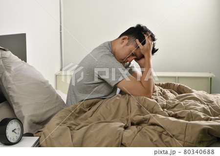 Depressed young Asian man sitting in bed cannot sleep from insomnia 80340688