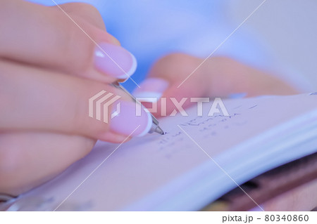Woman hand holding pen and writing to do list in vintage notebook organizer Woman hand holding pen and writing to do list in vintage notebook organizer 80340860