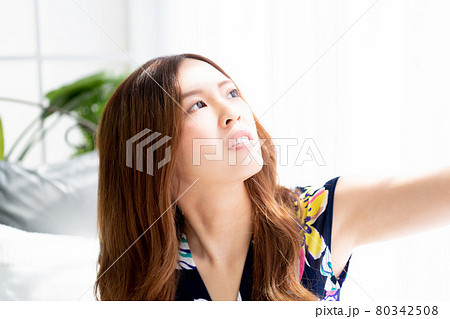 窓際でポーズをとる青いワンピースを着る若い女性の写真素材 窓際でポーズをとる青いワンピースを着る若い女性の写真素材