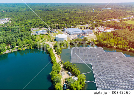 Panels floating on water with floating solar panels in a blue pond under the sunlight Panels floating on water with floating solar panels in a blue pond under the sunlight 80345269
