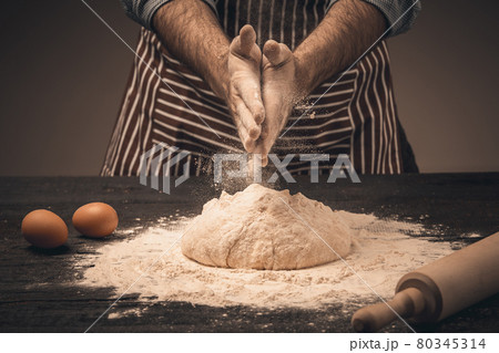 Male hands knead the dough. 80345314