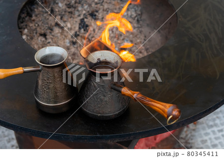 Preparing Turkish coffee with black cezve or ibrik at street food festival Preparing Turkish coffee with black cezve or ibrik at street food festival 80345411