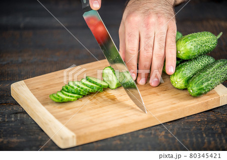 Male hands cutting vegetables for salad Male hands cutting vegetables for salad 80345421