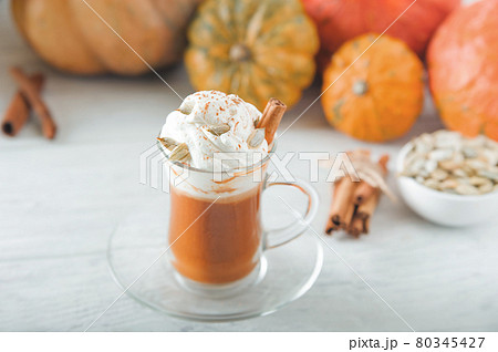 Pumpkin coffee in transparent cup and whipped cream with cinnamon. Autumn cappuccino or latte menu. Pumpkin coffee in transparent cup and whipped cream with cinnamon. Autumn cappuccino or latte menu. 80345427