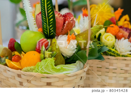 Close up: colorful fruits and flowers bouquet in wicker basket on table Close up: colorful fruits and flowers bouquet in wicker basket on table 80345428