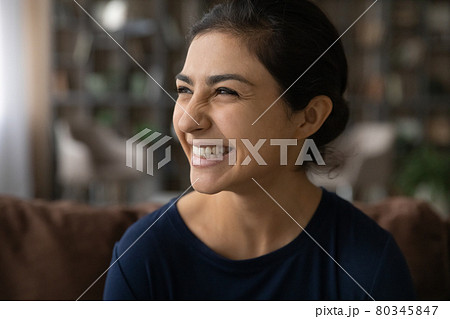 Smiling Indian woman look in distance dreaming laughing 80345847