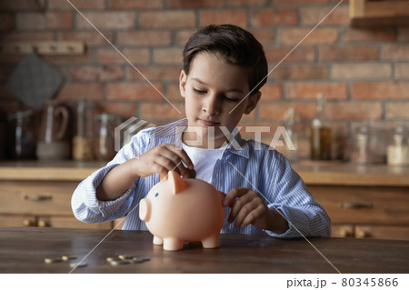 Focused school kid saving money for purchase Focused school kid saving money for purchase 80345866