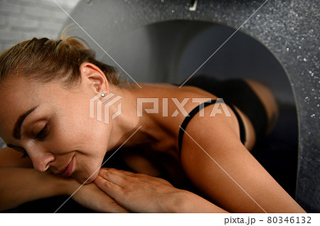 Headshot of woman with closed eyes relaxing during cosmetic procedure in spa capsule Headshot of woman with closed eyes relaxing during cosmetic procedure in spa capsule 80346132