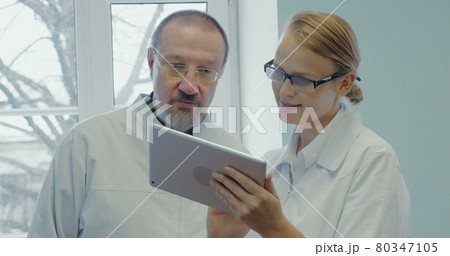 Two doctors having professional talk using touch pad Two doctors having professional talk using touch pad 80347105