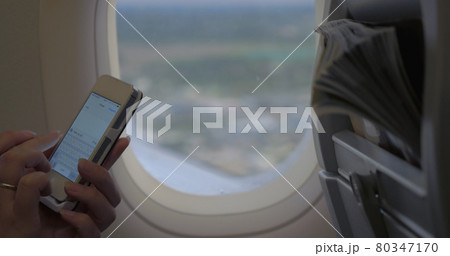 Woman typing sms in flying plane 80347170