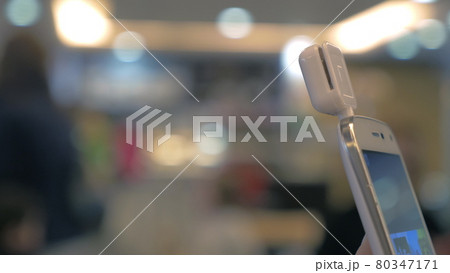 Girl using mobile terminal on phone and pays for purchase through card 80347171