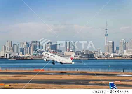 羽田空港第2ターミナルを離陸したjal機と東京スカイツリー の写真素材