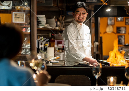 厨房で調理するシェフと客 80348711