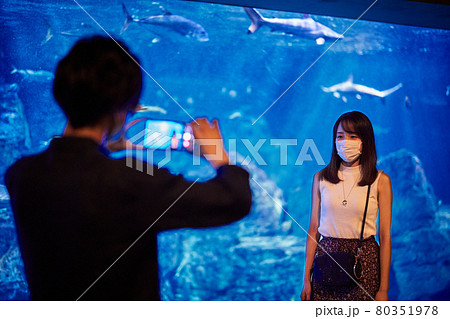 水族館デートで記念撮影する若いカップルの写真素材