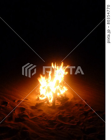 夜の砂地でのキャンプファイヤーで炎が燃える様子縦位置 夜の砂地でのキャンプファイヤーで炎が燃える様子縦位置 80354770