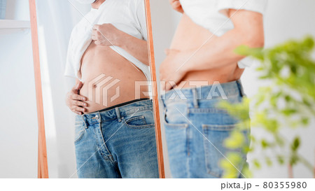 お腹のぜい肉を触る男性 ダイエットイメージ お腹のぜい肉を触る男性 ダイエットイメージ 80355980