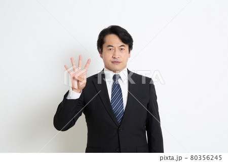 真顔で指を4本立てている中年サラリーマン男性 80356245