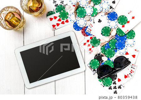 Gambling. Poker chips, cards and the dice nearby tablet on wooden table. Top view. Copyspace. Poker Gambling. Poker chips, cards and the dice nearby tablet on wooden table. Top view. Copyspace. Poker 80359438